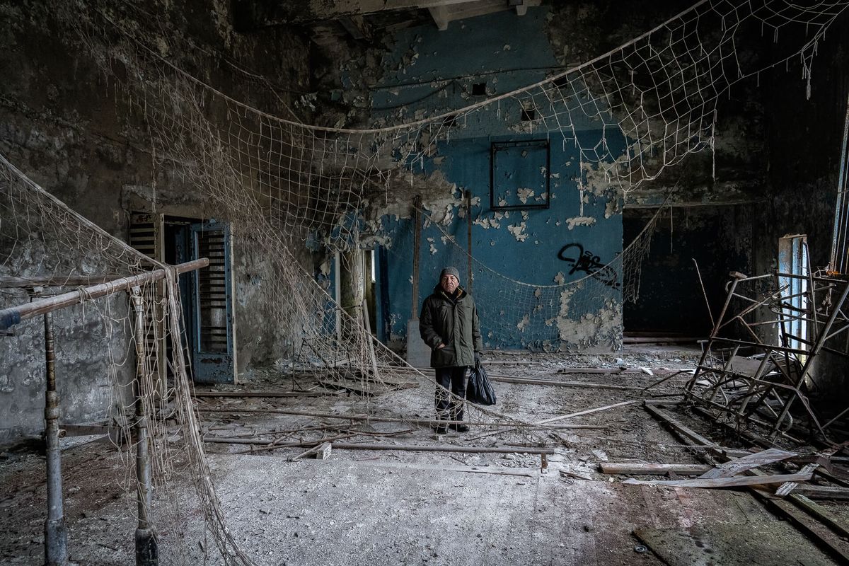 Man stood in derelict building.