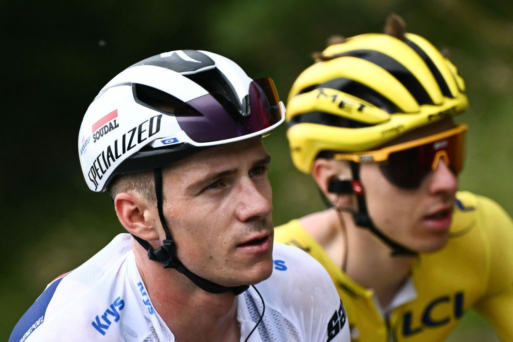 Soudal Quick-Step team's Belgian rider Remco Evenepoel wearing the best young rider's white jersey (L) and UAE Team Emirates team's Slovenian rider Tadej Pogacar wearing the overall leader's yellow jersey (R) cycle in the ascent of the Cime de la Bonette during the 19th stage of the 111th edition of the Tour de France cycling race, 144,6 km between Embrun and Isola 2000, in the French Alps, on July 19, 2024. (Photo by Marco BERTORELLO / AFP)