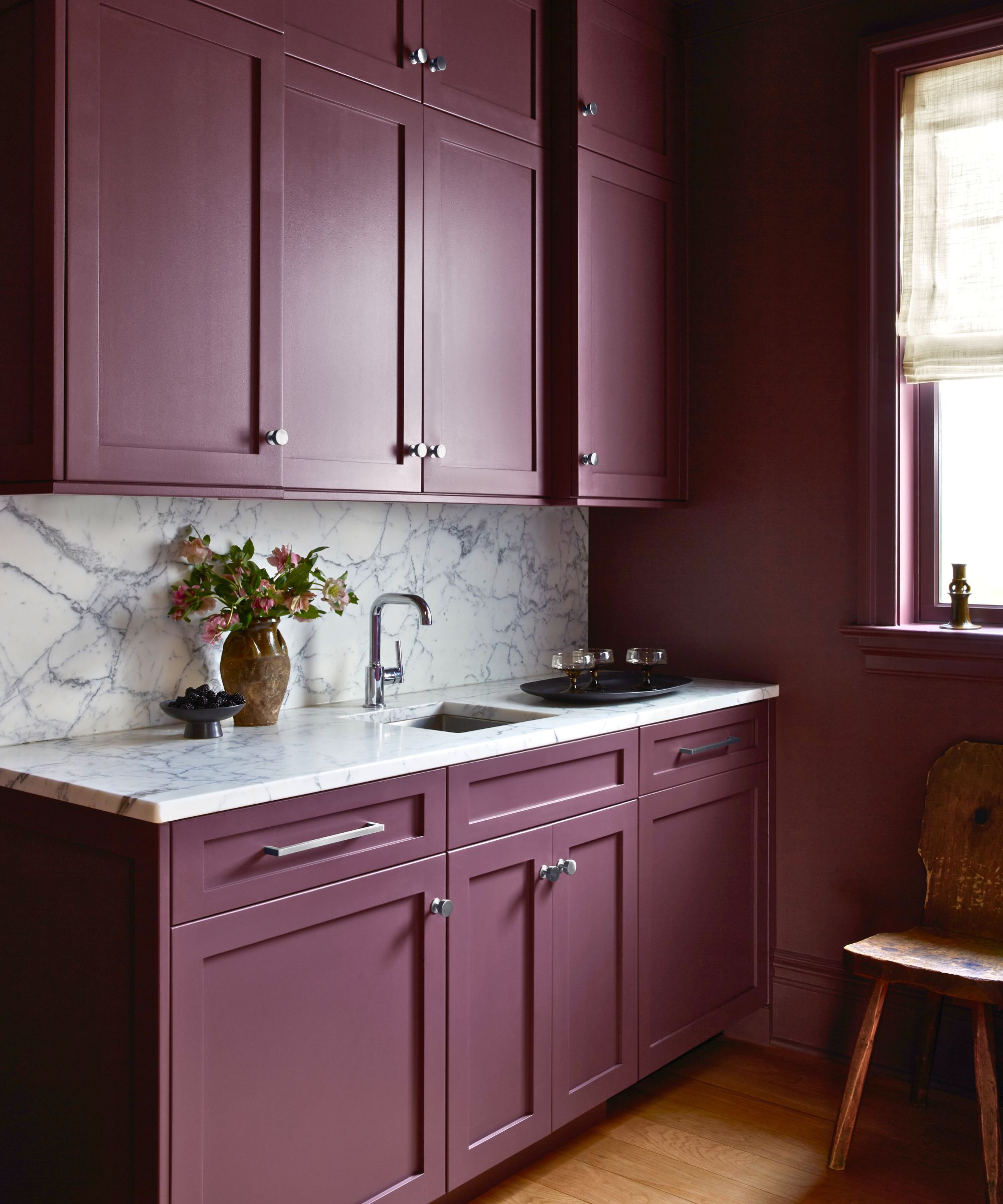 butlers pantry with dark purple walls and marble counters