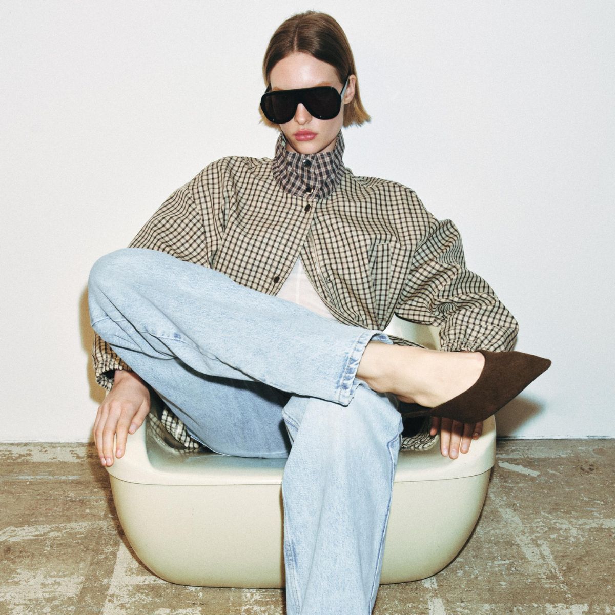 a model wearing a zara jeans, jacket and sunglasses