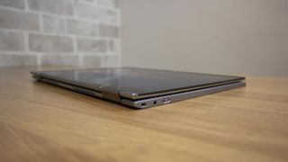A photograph of the Lenovo ThinkPad X1 Titanium Yoga closed on a desk