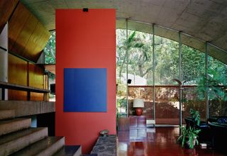 Concrete house with curved ceiling and red and blue feature wall