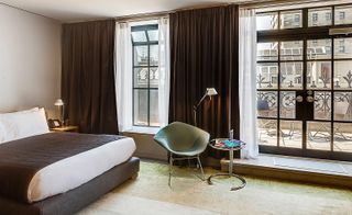 Guestroom with large windows & glass doors leading to blacony