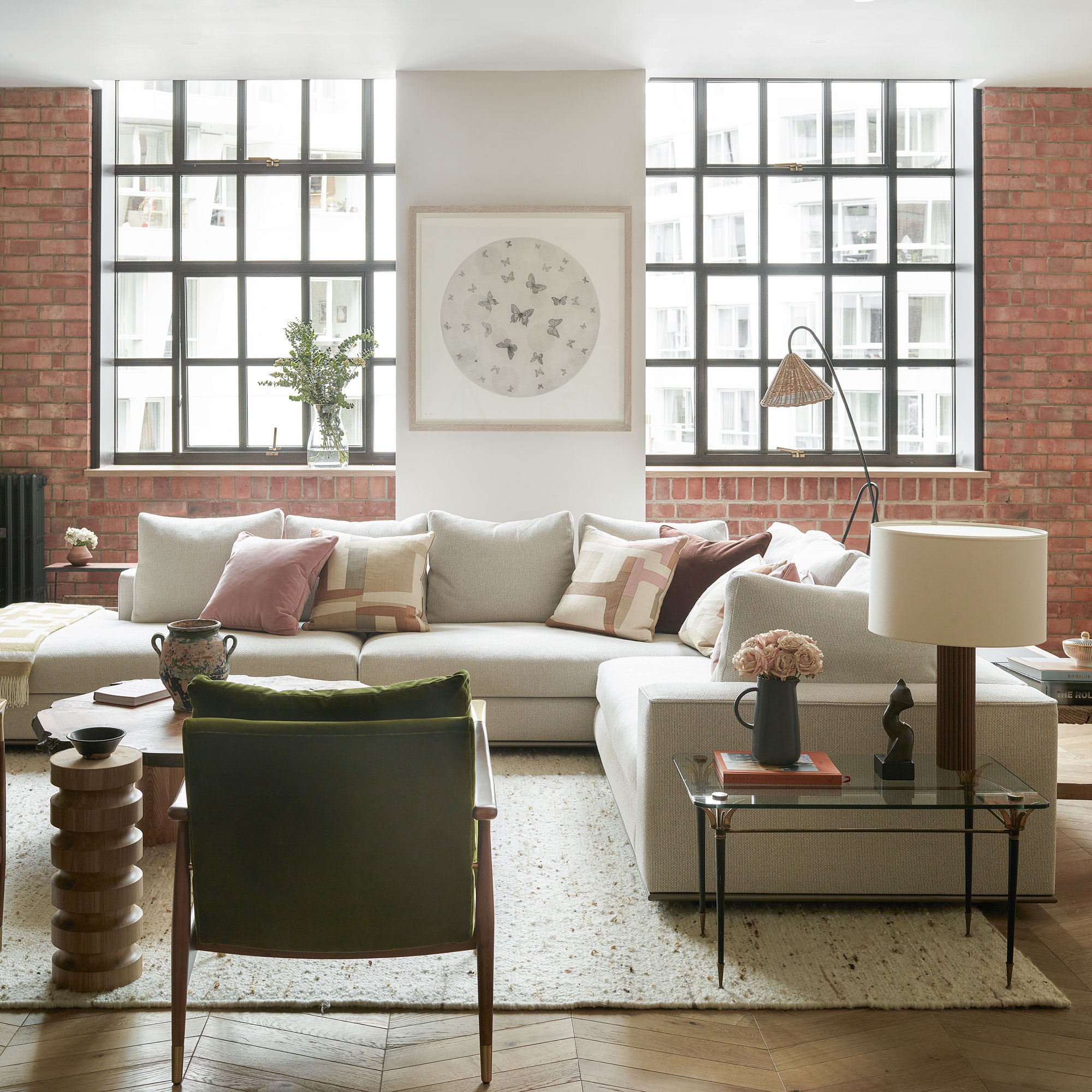 Apartment with brick walls, white corner sofa and green armchair