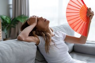 Woman fanning herself with paper fan