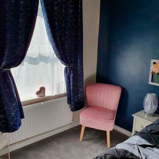 bedroom with window with blue curtains and pink chair