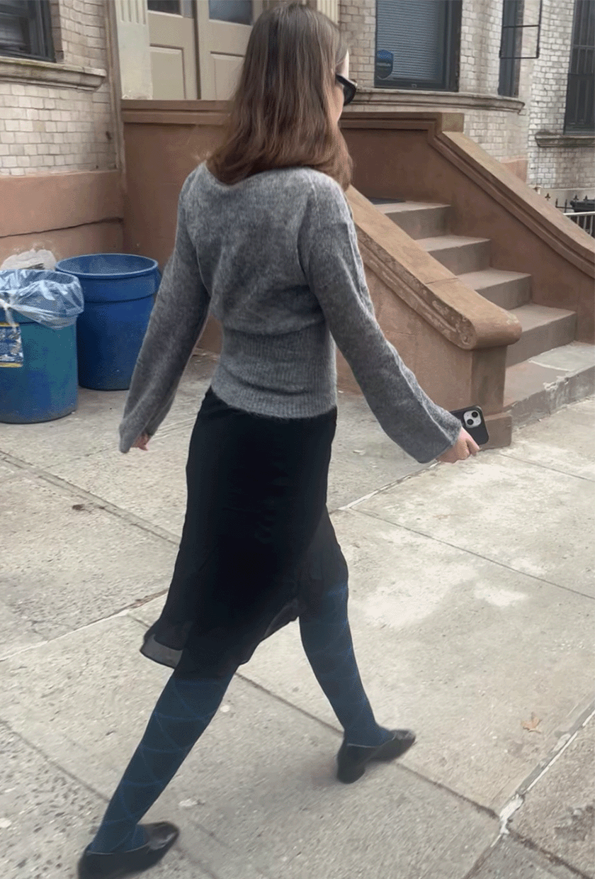 Audry Hiaoui wearing the Soren Sheer Alpaca Sweater Top, Layla Knee-Length Skirt, and Reformation Inez Pumps.