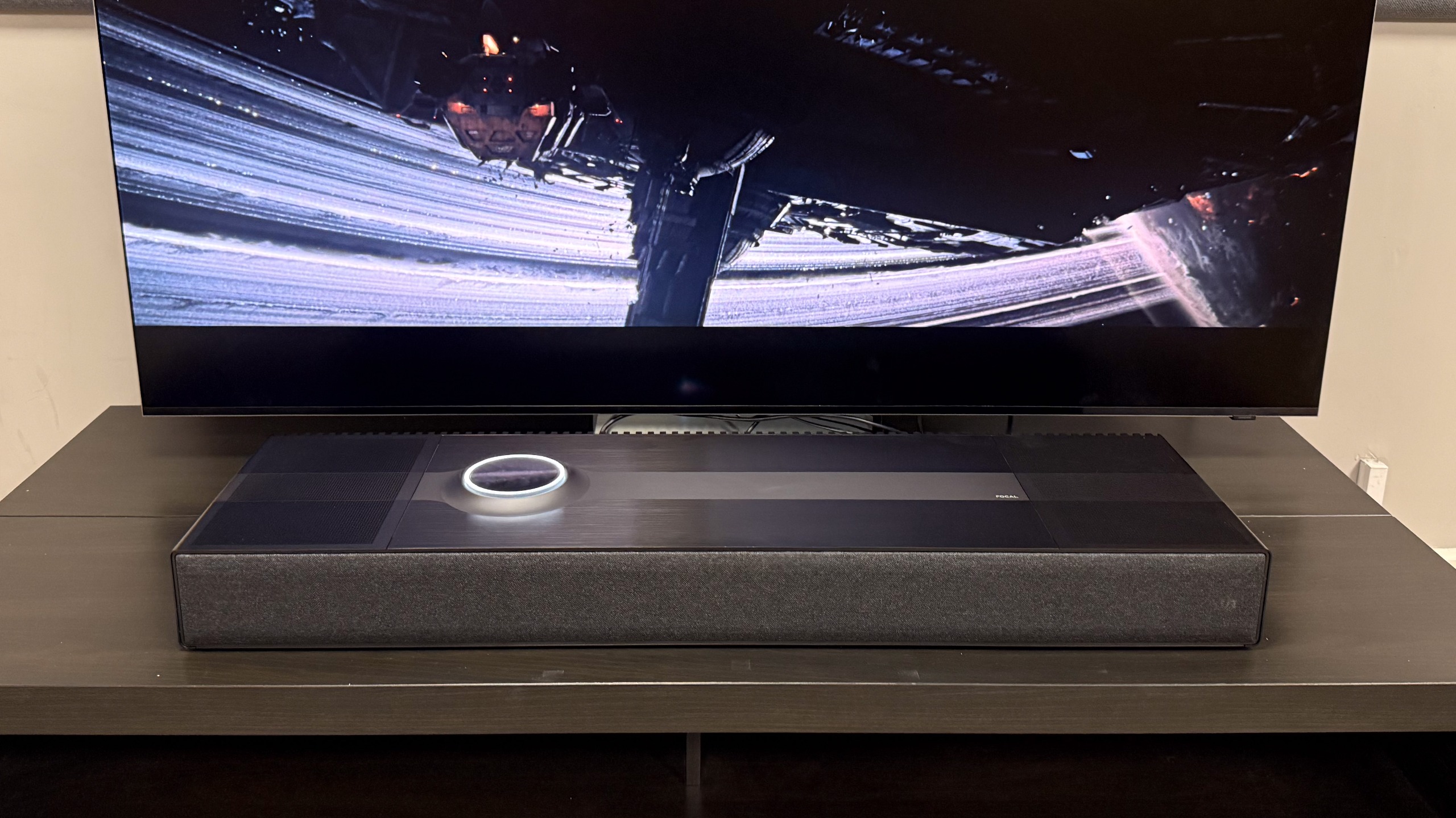 The Focal Mu-so Hekla in front of the Samsung R95H showing a scene from Alien: Romulus.