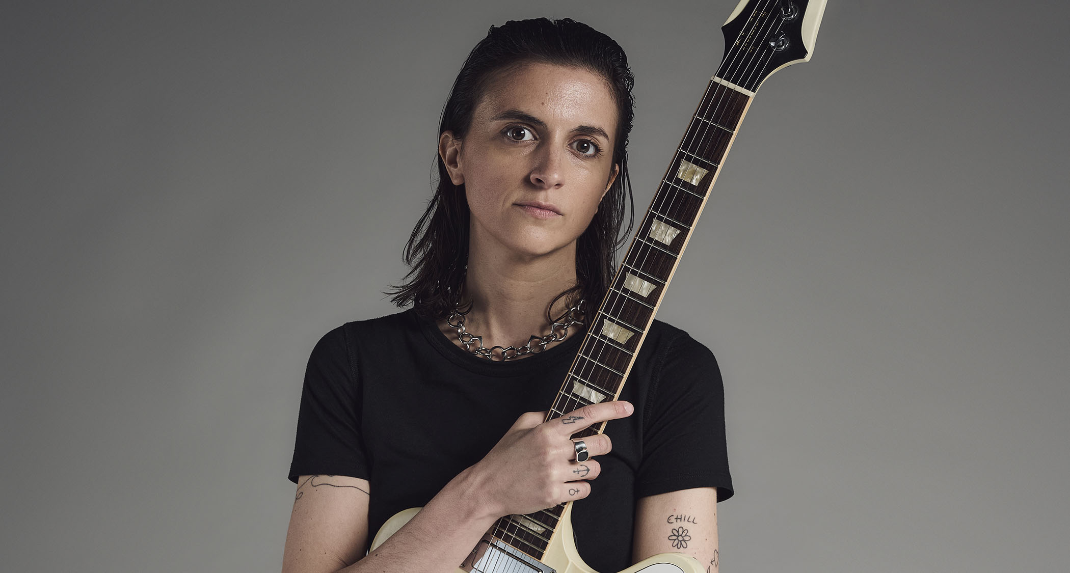 Laura Cox photographed with her white Gibson Firebird