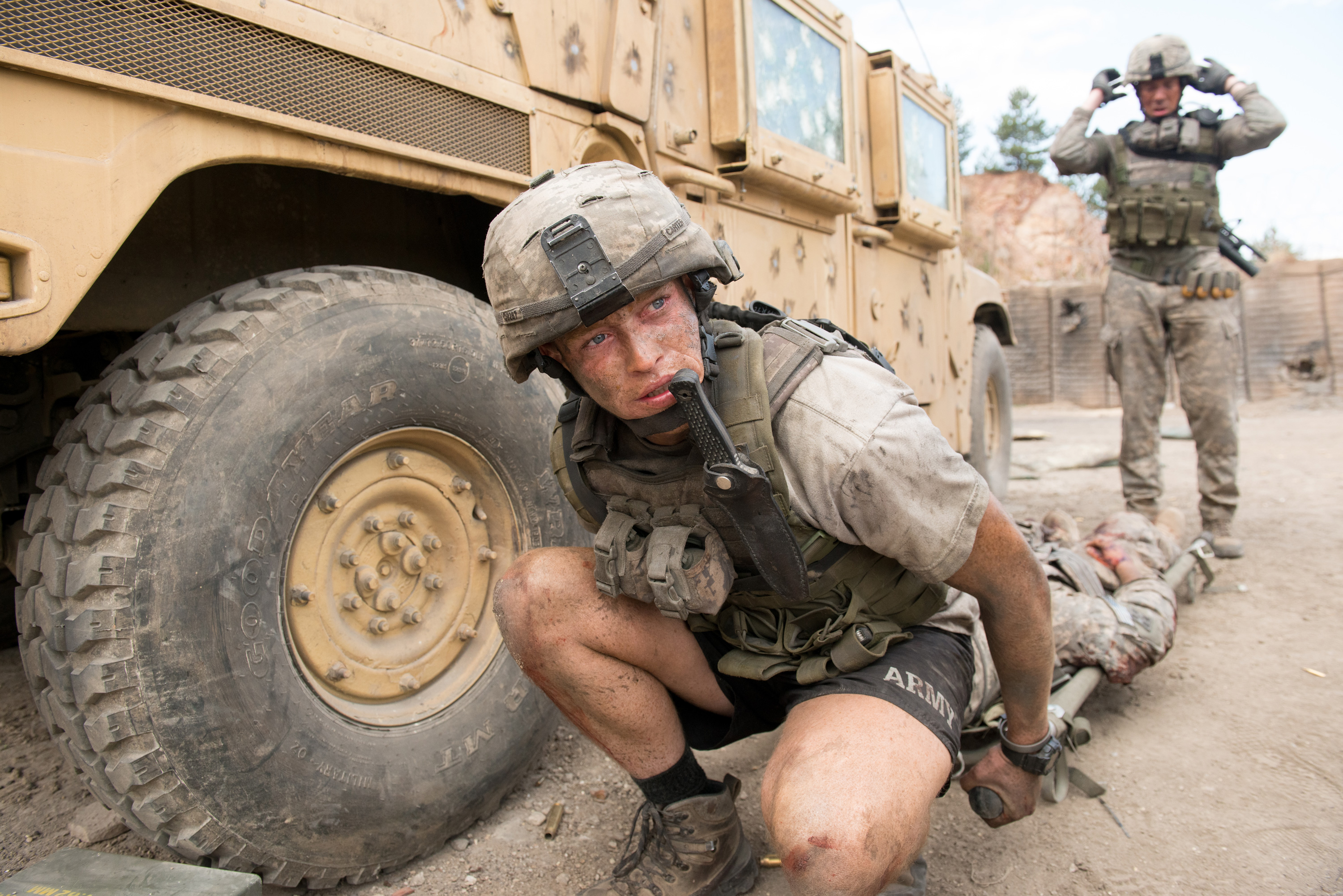 a solider kneeling while moving a body on a gurney in The Outpost, one of the best netflix war movies
