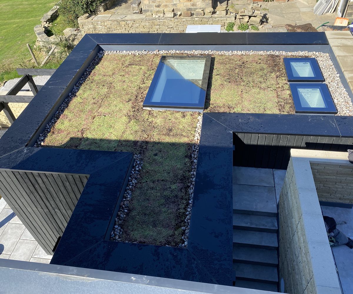 A progress photo of a flat roof planted with a living sedum mat