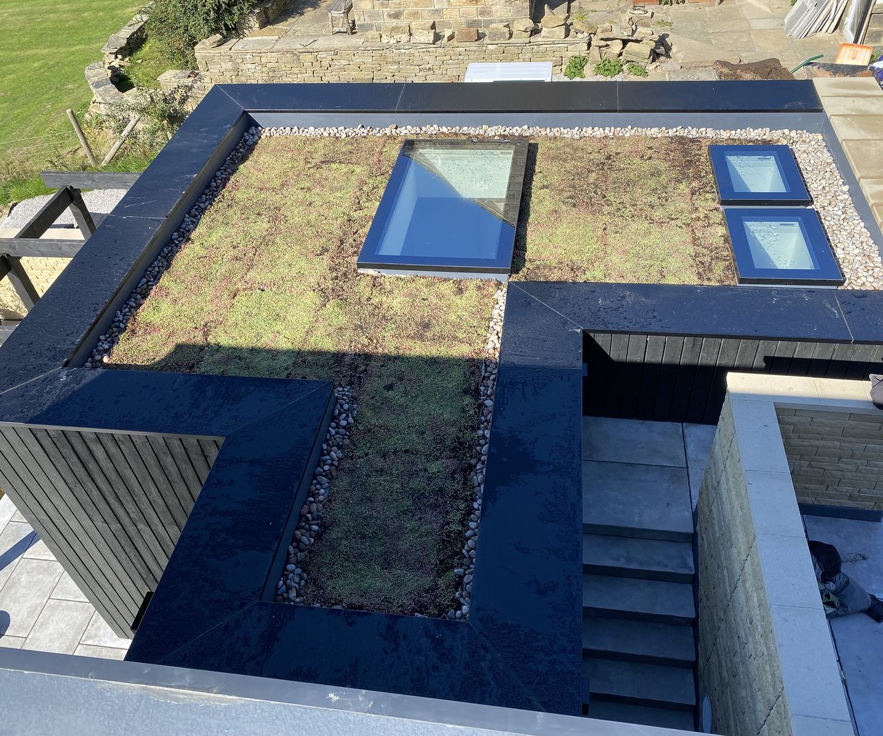 A progress photo of a flat roof planted with a living sedum mat