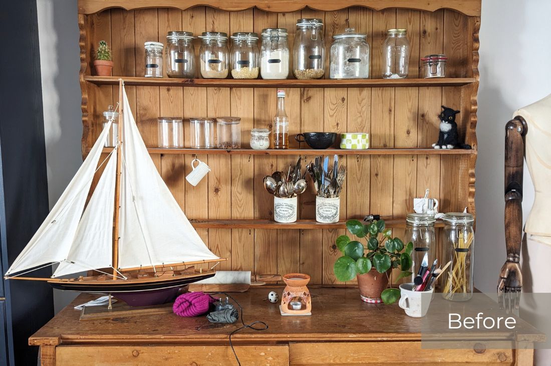 Before photo of my dining room dresser organized using the 5x5 Cleaning Method. First shows open shelving with jars and ornaments plus random items on the surface. It looks cluttered and the model sail boat is lost in the melee