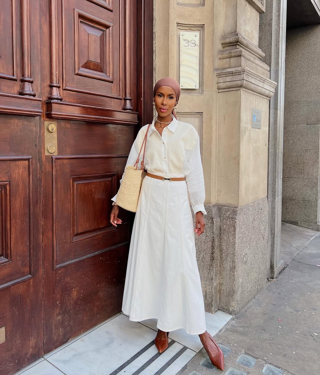 Basma in white skirt and blouse with basket bag