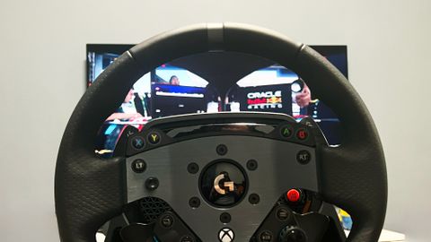 Logitech G Pro Racing wheel review image showing the wheel in front of a TV displaying a driving sim game