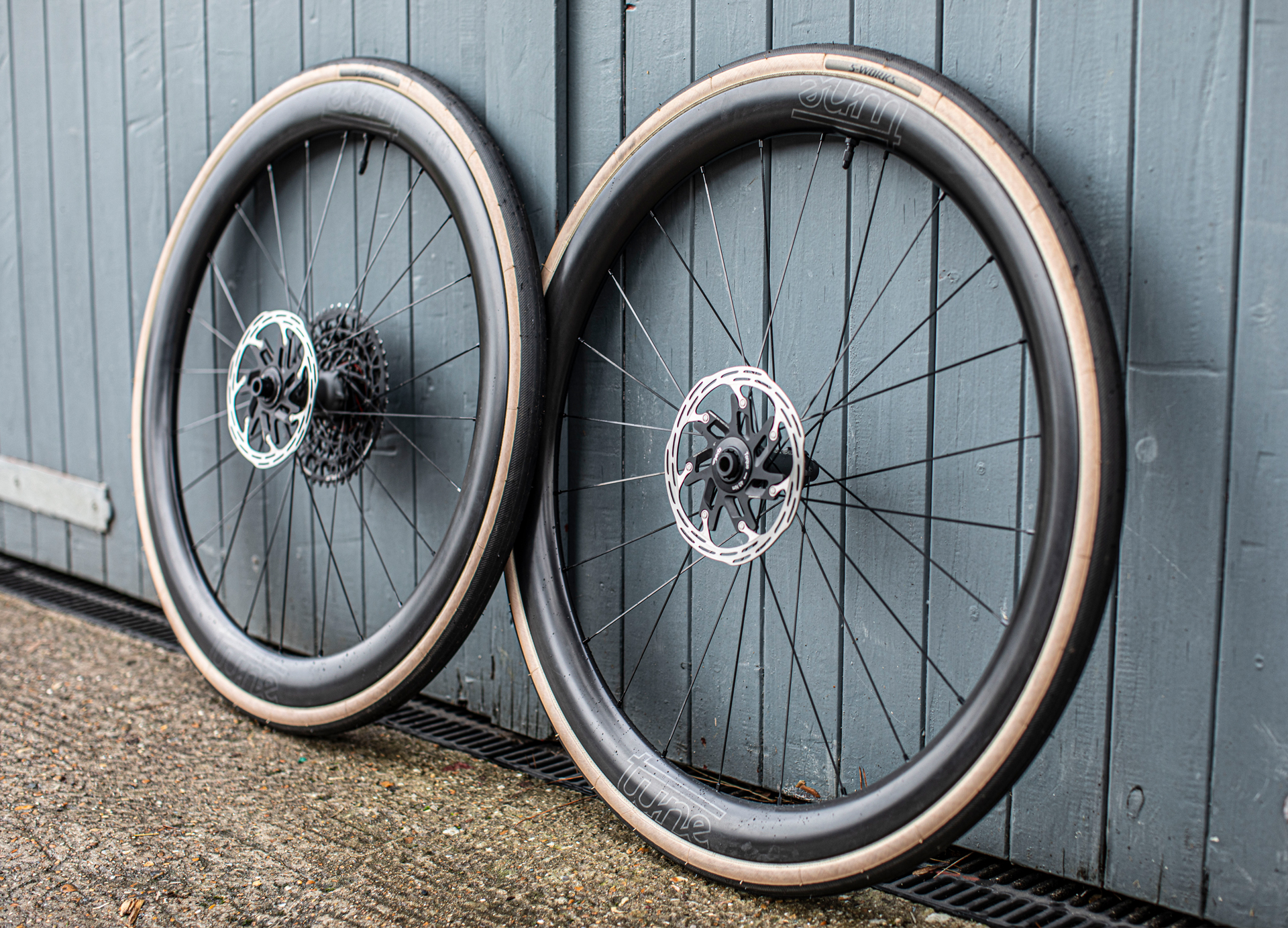 Tune Yokto 4550 wheels leaning against a wooden door painated blue