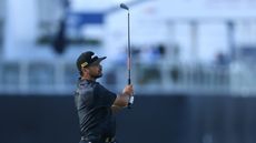 Jason Day hits an iron shot and watches it