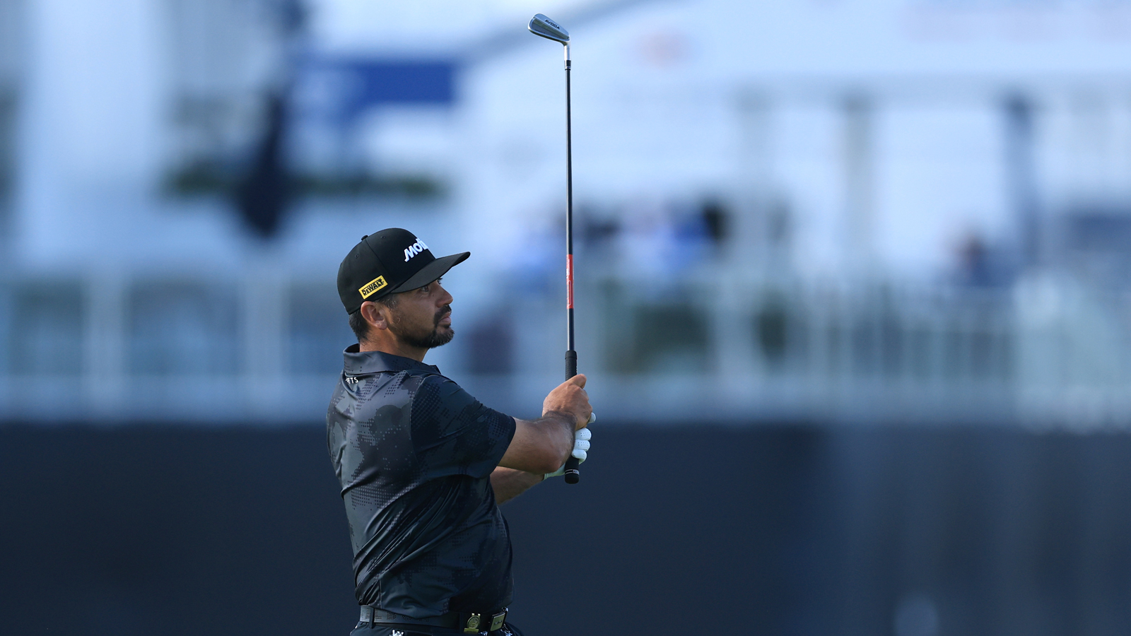 Jason Day hits an iron shot and watches it