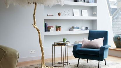 living room with white shelf on wall and feather lamp