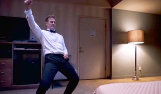 Room 104 James van der Beek dancing in a tuxedo shirt and pants in a hotel room