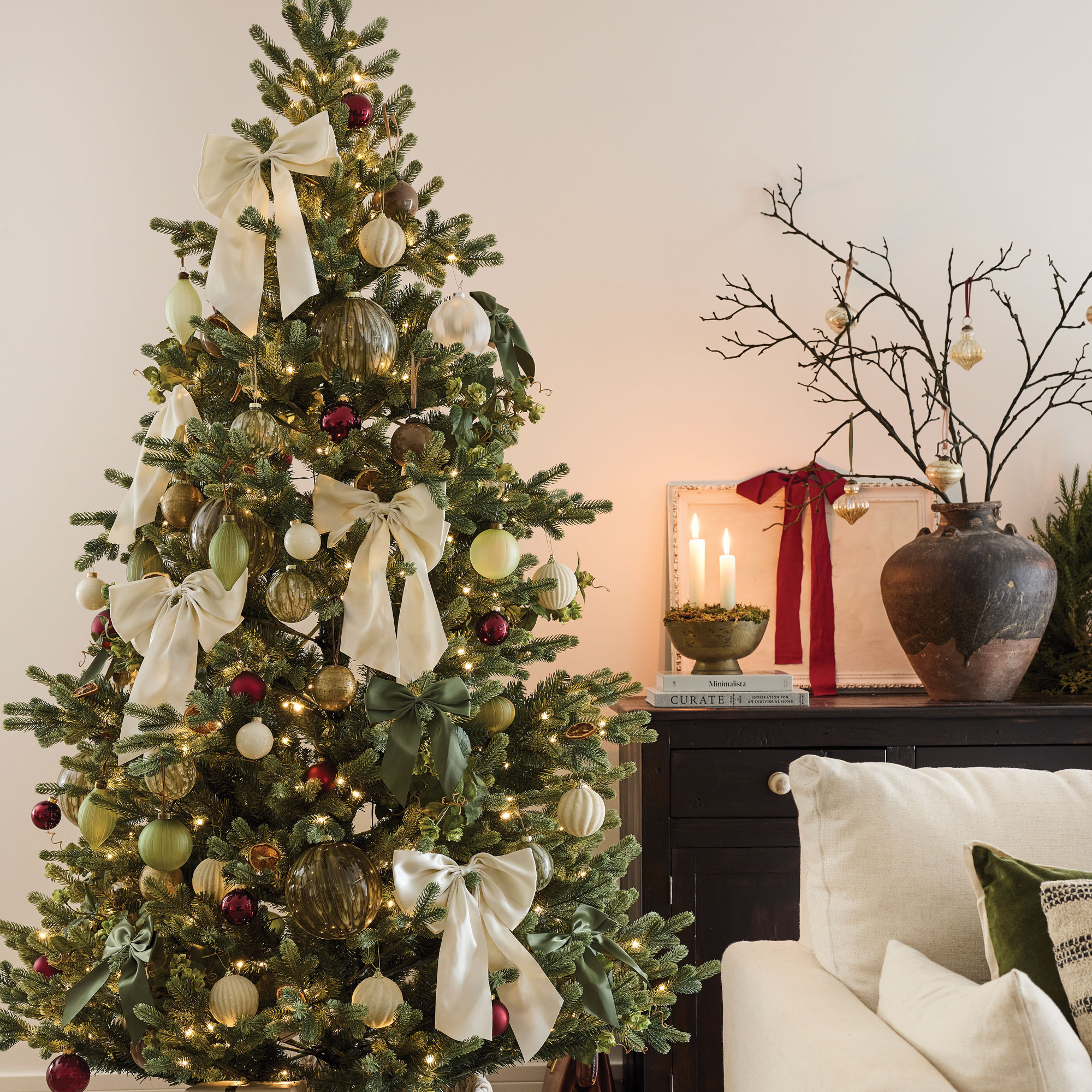 Christmas tree in a white room decorated with cream fabric bows