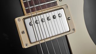 Close up of guitar strings and an electric guitar pickup