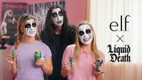 Three people wearing dramatic, black-and-white heavy metal face paint smile while holding up e.l.f. cosmetics tubes and Liquid Death beverage cans next to a promotional "e.l.f. x Liquid Death" logo.