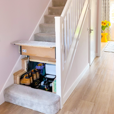 Carpeted stairs lifted to reveal the storage space below.