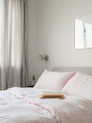 pale grey bedroom with white walls, grey curtains, pink bedding
