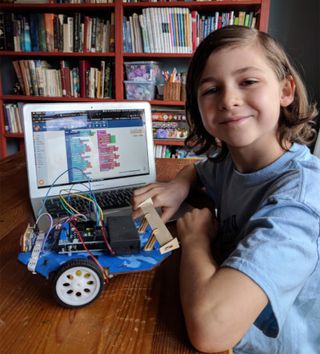 Boy with laptop computer and robot
