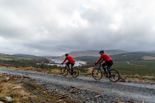 Two male cyclists riding on gravel