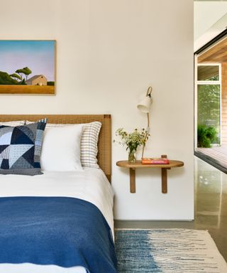 modern bedroom with white wall, blue bedding