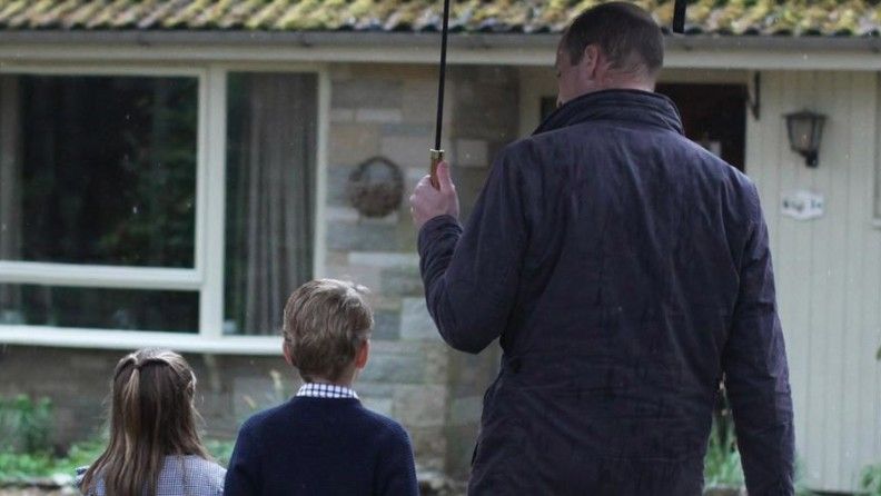 Prince William holds an umbrella over Prince George and Princess Charlotte