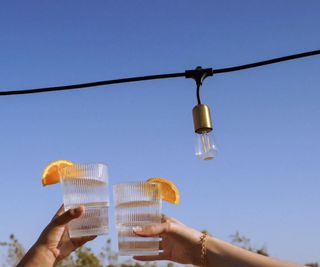 Brightech solar lights above a close up of two drinks glasses