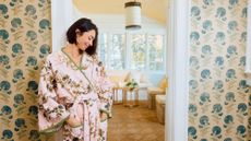 A model poses in a pink-and-green floral Weezie terry robe from the new Leah O'Connell collaboration inside a pattern-filled entryway