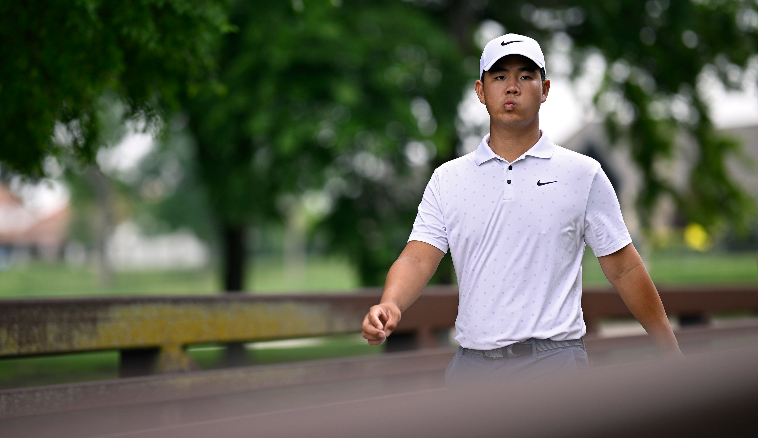 Tom Kim walks over a bridge