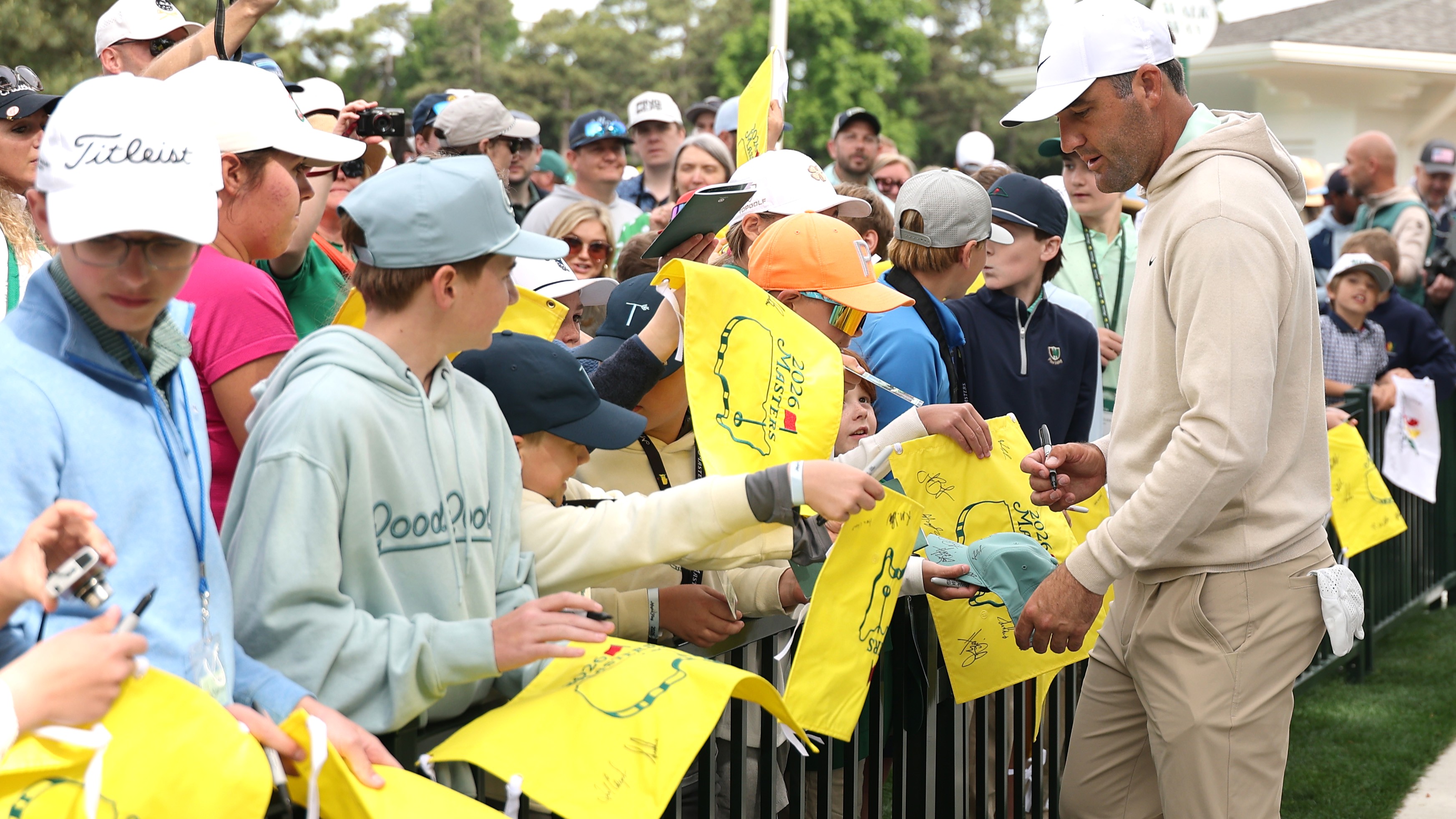 Scottie Scheffler signs autographs for the patrons at one of the Masters practice days