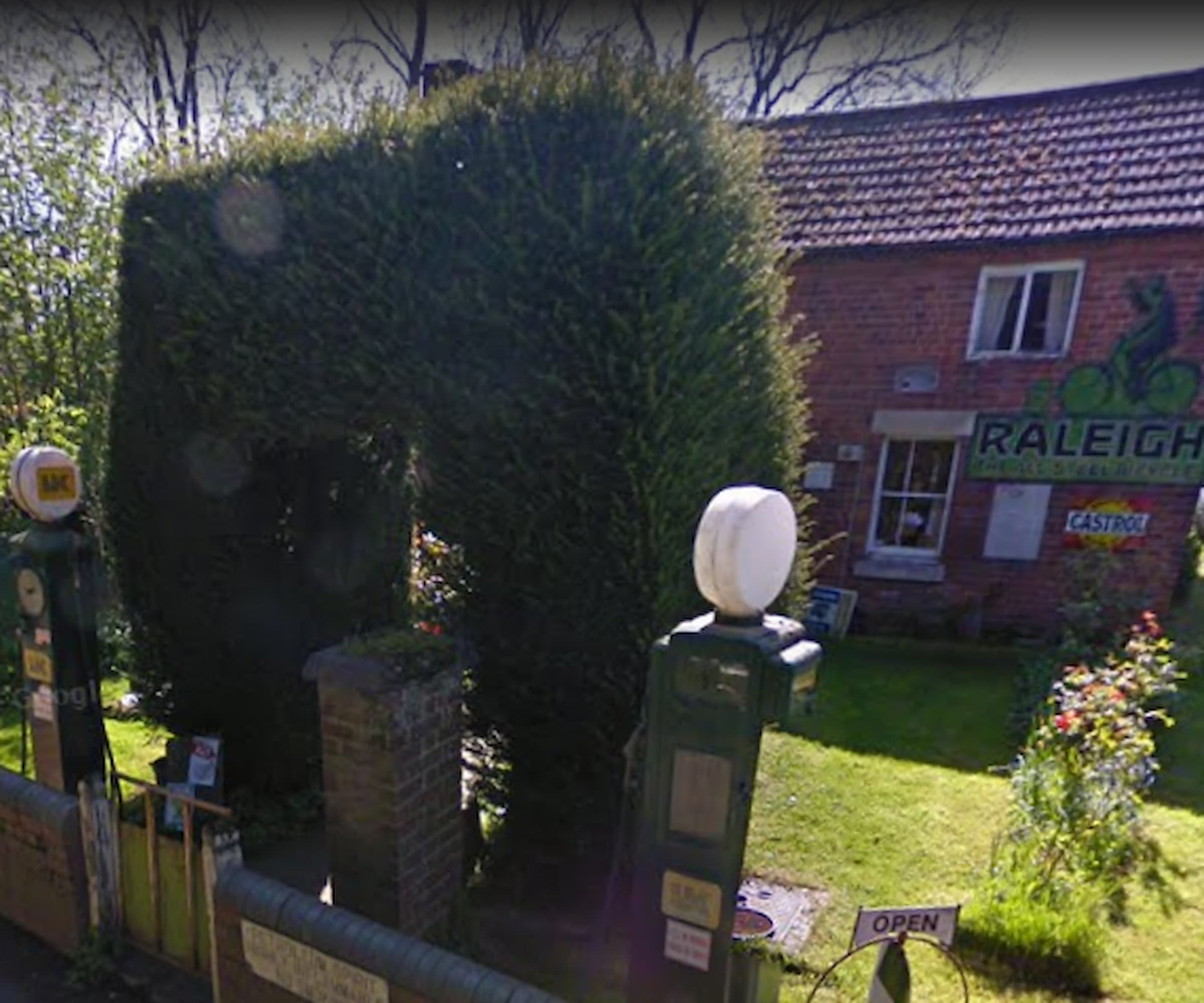 The front wall is a stone structure where the petrol pumps sit next to with hedges above them making an arch