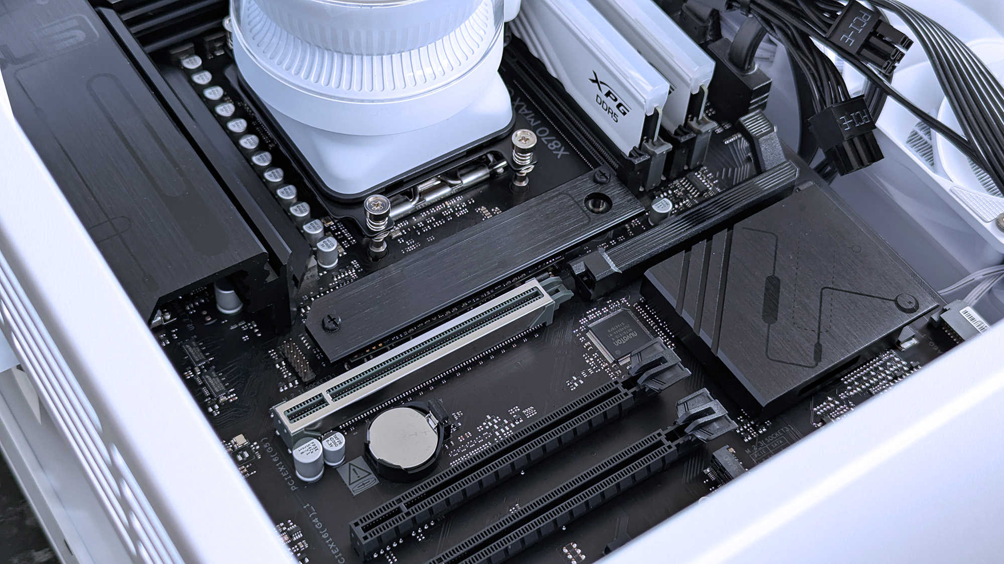 Close-up of an iBUYPOWER RDY Trace X R01 pre-built gaming PC motherboard inside a white case. Features visible include RAM, processor, cooling system, expansion slots, and cables