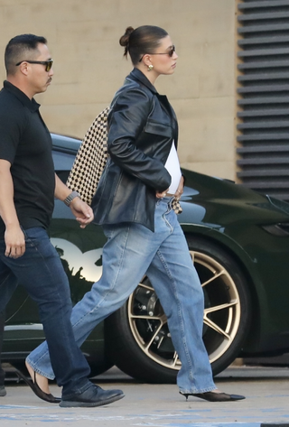 Hailey Bieber is seen arriving at Nobu on July 15, 2024 in Malibu, California in jeans, a leather jacket, and Bottega Veneta's checkered Hop bag.