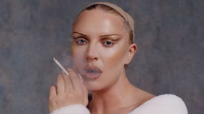 Self Esteem's Rebecca Taylor in a white robe smoking a cigarette