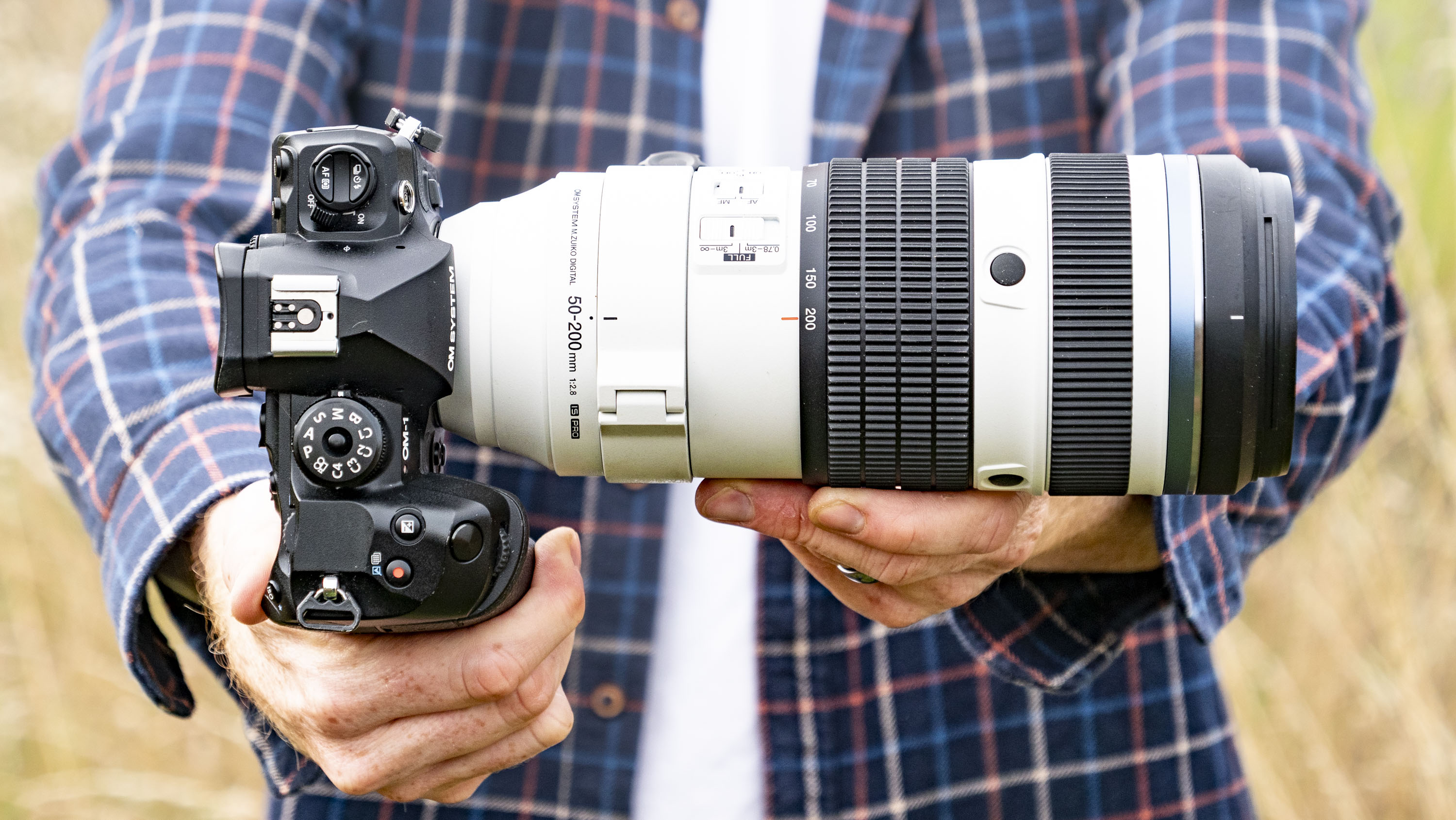 OM System M.Zuiko Digital ED 50-200mm F2.8 IS Pro lens in photographer's hands