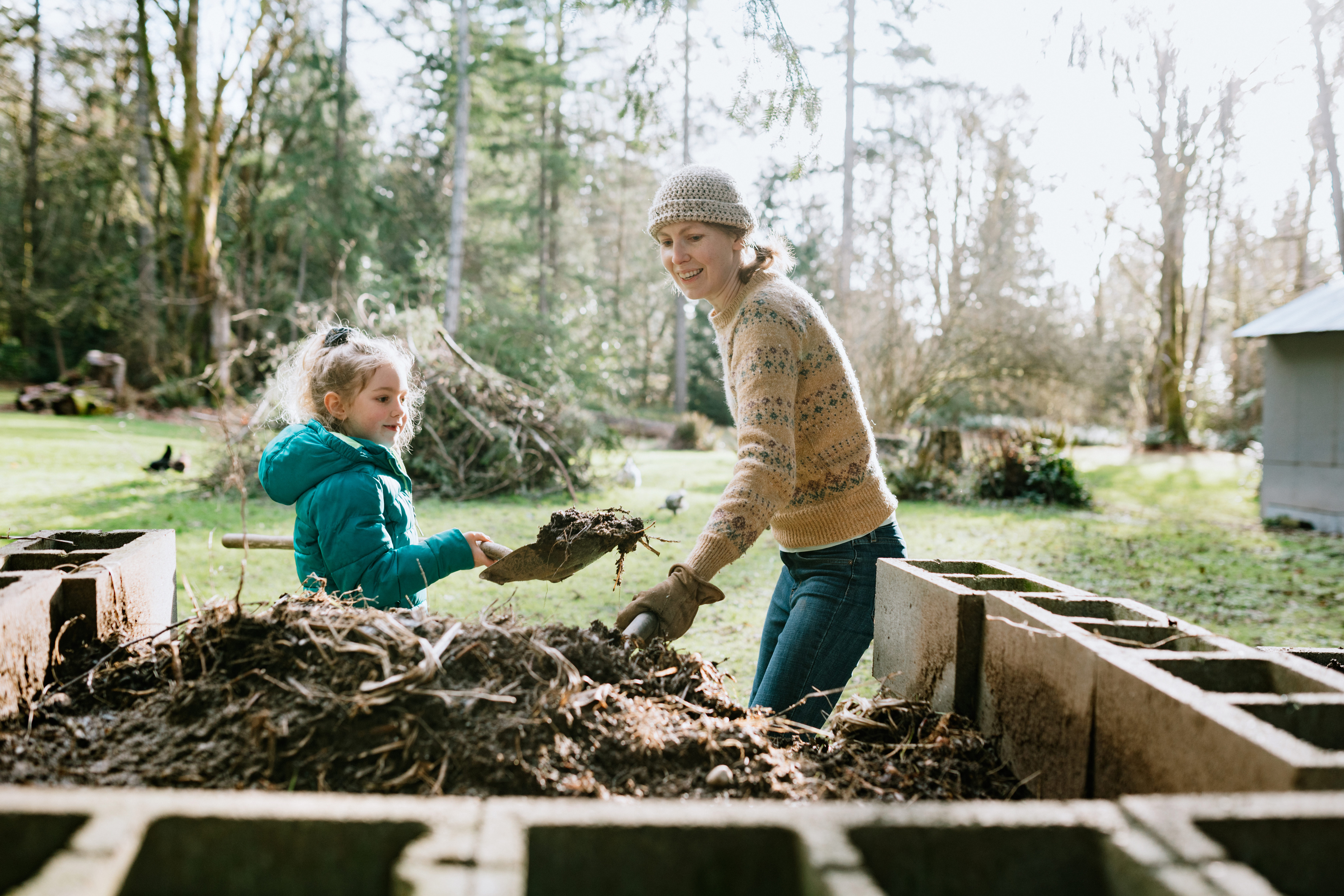 Mum and kid adding to a compost heap