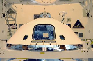 Once mated to its descent stage, the Mars Science Laboratory will be placed inside its aeroshell that will protect Curiosity during its deep space cruise to Mars. The hatchway opening in the aeroshell will allow engineers access a few days before launch t