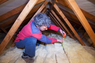 A Mambi installing insulation in his loft space