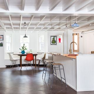 Mismatched chairs in an open plan kitchen diner with kitchen island