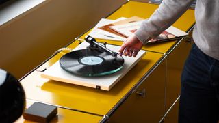 A turntable with a person's hand 
