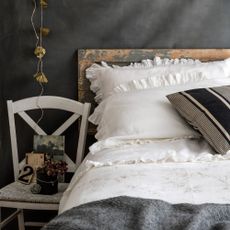 Ruffled pillows on a bed with a chair
