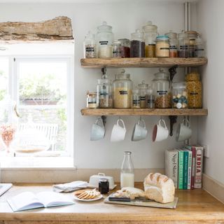 Kitchen with jars storing pasta and non-perishable goods, bread, cookies, and milk on worktop