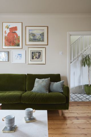 living room with velvet green sofa and gallery wall